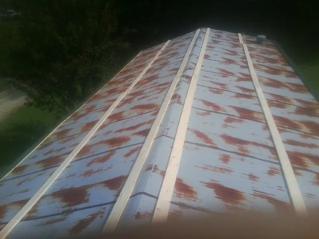Rusted metal roof panels with new wood purlins before replacement — Storm Damage Roof Repair in Burgess by Roofing Brothers