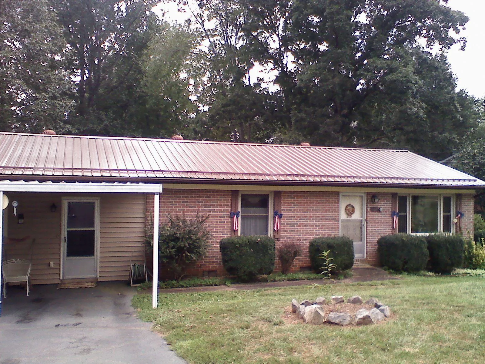 Bronze metal roof and carport on a brick ranch home — Roof Repair work by our crew in Burgess